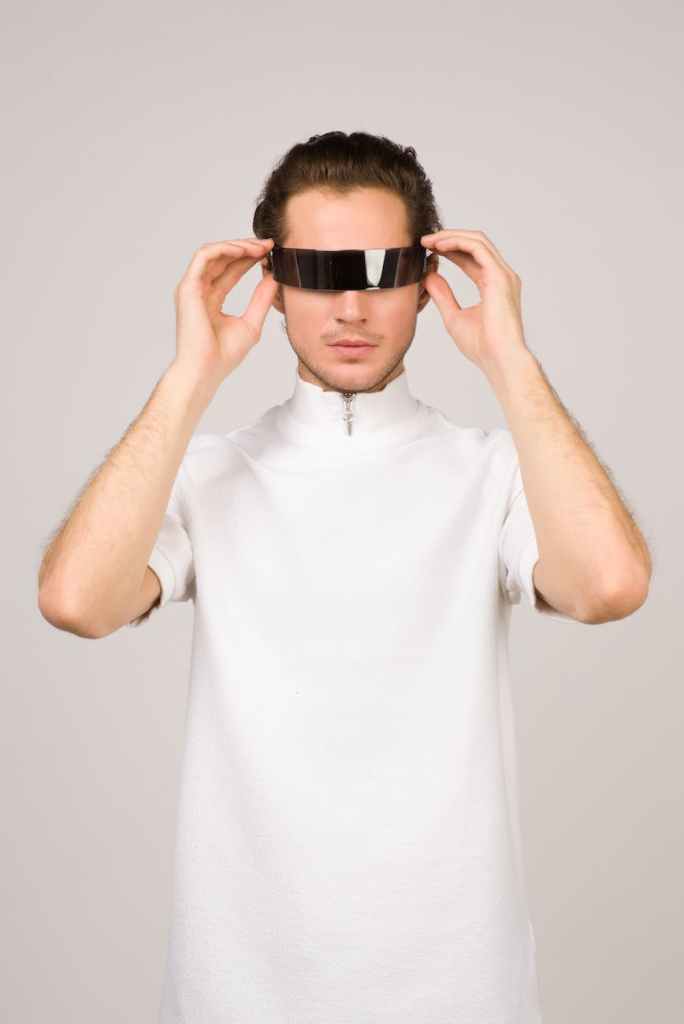 Man with futuristic sunglasses and cutting edge mock turtleneck.